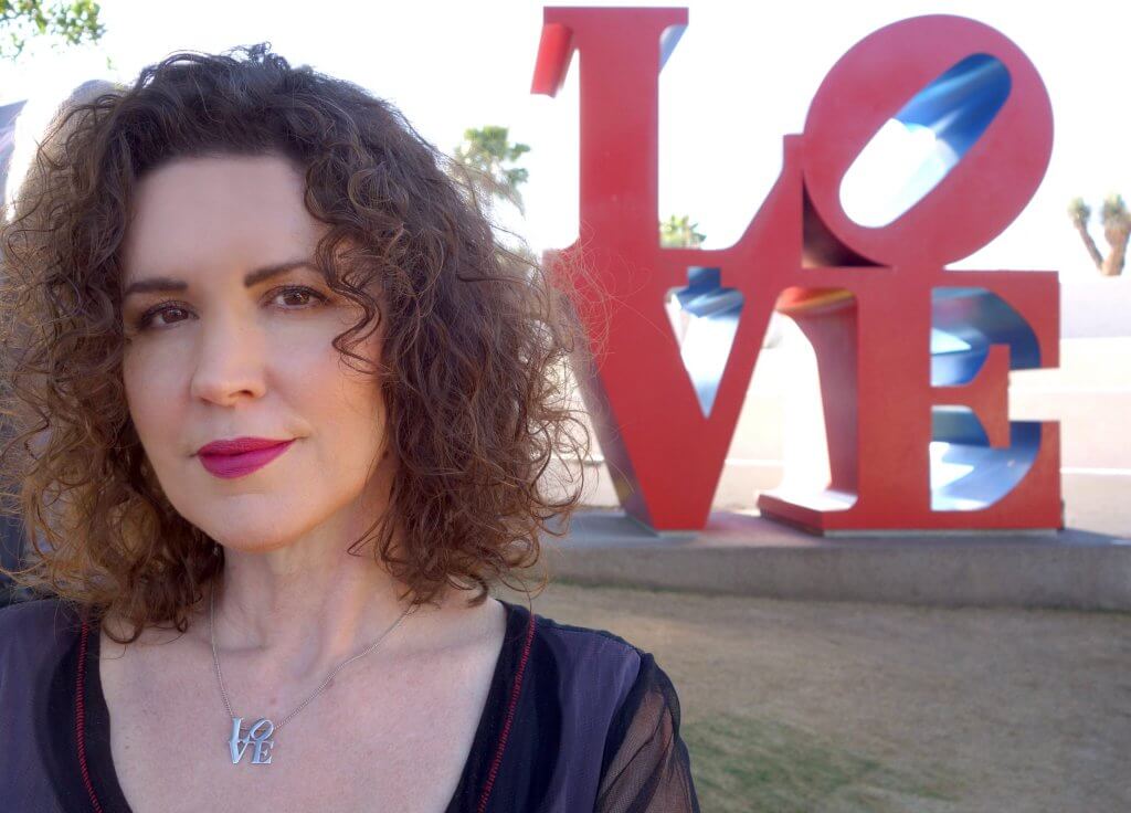 Photo of Crista Cloutier with big letter statues at the back "LOVE"