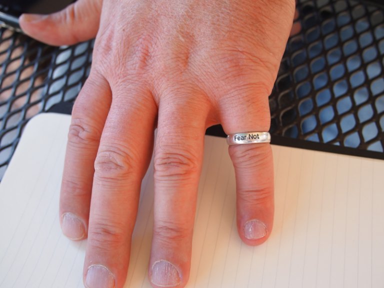 Photo of a hand with a "Fear Not" ring on the smallest finger